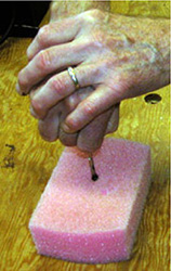 a person exerting pressure on a piece of foam